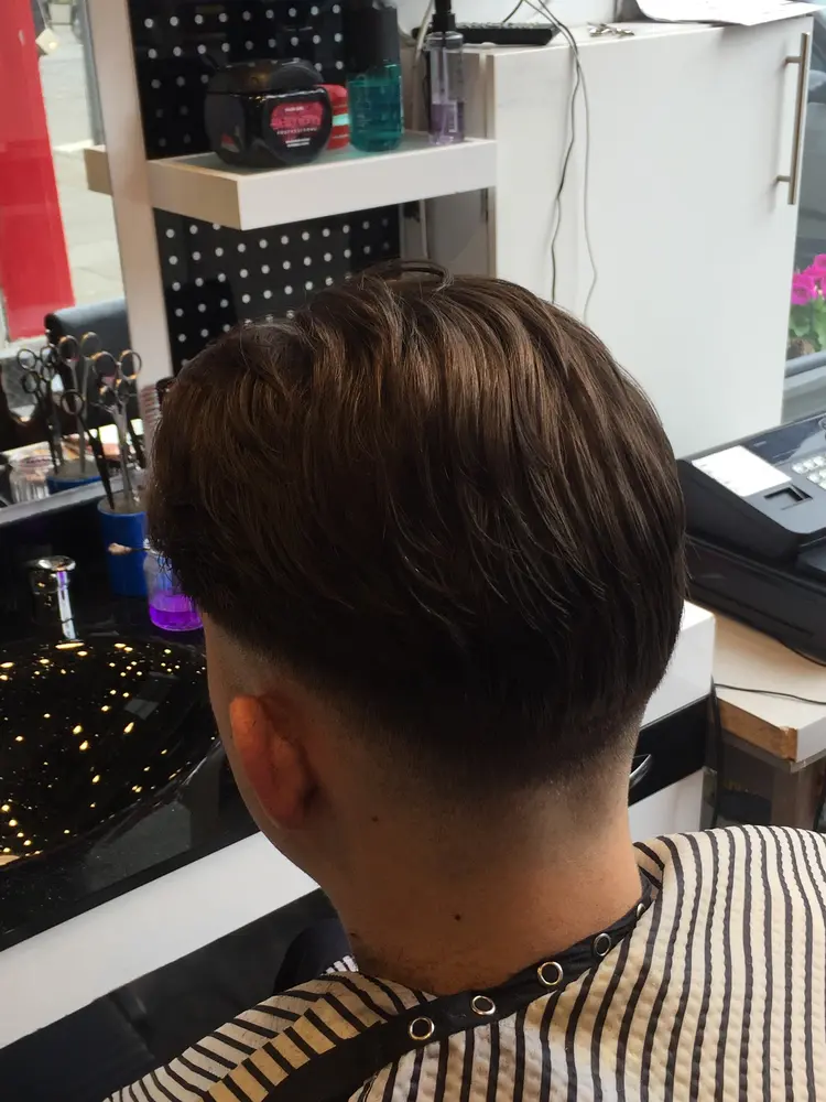 Finished pompadour with tonic, geraniums visible in the shop window